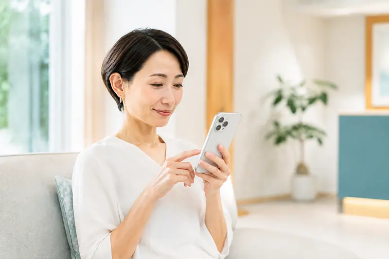 スマートフォンからWEB診療予約をする女性